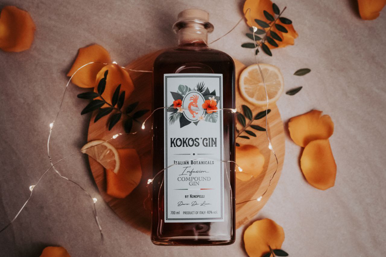 Bottiglia di Kokos' Gin con fette d'arancia e luci